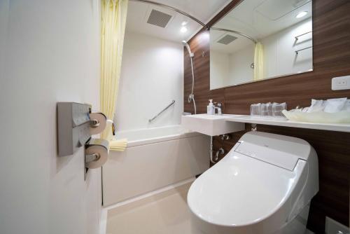 a bathroom with a toilet and a sink and a tub at Hotel Riverge Akebono in Fukui