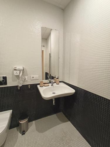 a bathroom with a sink and a mirror and a toilet at Apartamentos La Higuera by VGH in Jerez de la Frontera