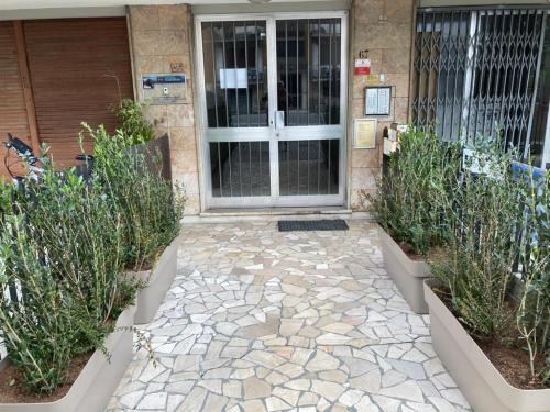 une porte d'entrée d'un bâtiment avec deux plantes en pot dans l'établissement Dal Ciandri, à Pise