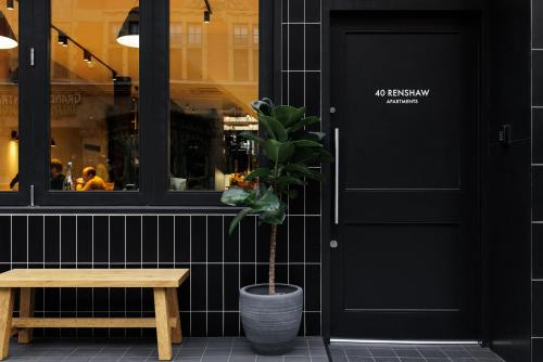 a potted plant sitting next to a bench and a door at 40 Renshaw Apartments in Liverpool