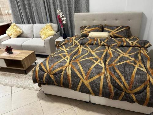 um quarto com uma cama e um sofá em Rayyan Stays em Dubai