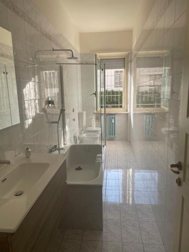 uma casa de banho branca com uma banheira e um lavatório em Daniela; vacanza e/o lavoro em Nichelino