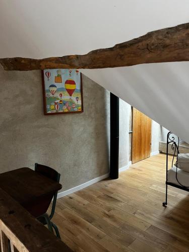 una sala de estar con una mesa y una pintura en la pared en Gîte des 3 Marchands, en Buzançais
