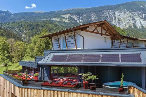 ein Haus mit einem Solarium auf dem Dach mit einem Berg in der Unterkunft Das Urgestein in Stans