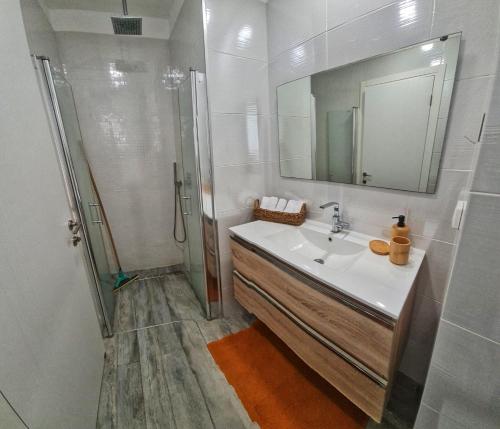 a bathroom with a sink and a shower with a mirror at Ben house in Tiberias