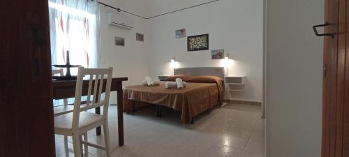una camera con letto, tavolo e sedia di Casa Rosmary a Cefalù