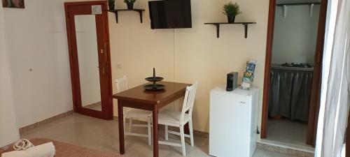 una cucina con un piccolo tavolo e un frigorifero di Casa Rosmary a Cefalù