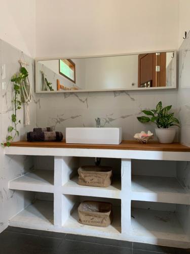 eine Badezimmertheke mit einem Waschbecken und einem Spiegel in der Unterkunft The Secret Karimunjawa in Karimunjawa