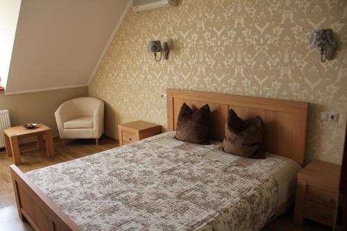 a bedroom with a large bed and a chair at Guest House Romantika Panzio in Gyula