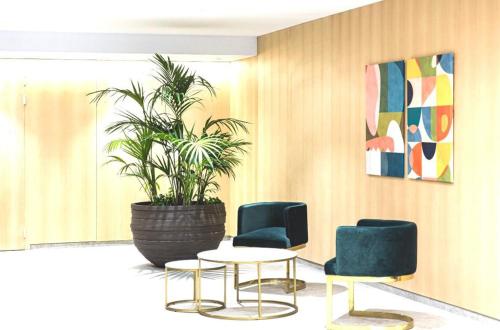 a room with chairs and a table and a potted plant at Intempo privat luxury apartment & spa in Benidorm