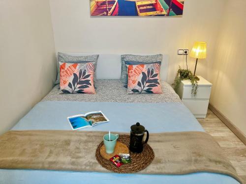 Un dormitorio con una cama con una bebida y un libro en Amazing Badalona Apartment With Terrace, en Badalona