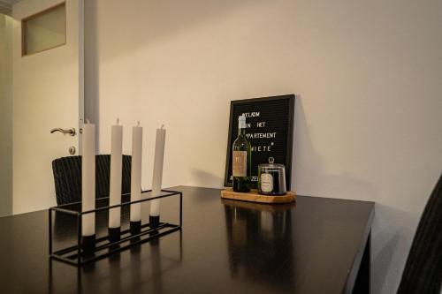 a table with a bottle of wine and candles on it at Appartement Miete - dichtbij strand en winkels in Bredene