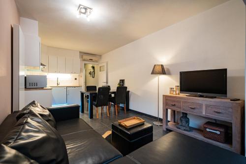 a living room with a couch and a flat screen tv at Appartement Miete - dichtbij strand en winkels in Bredene