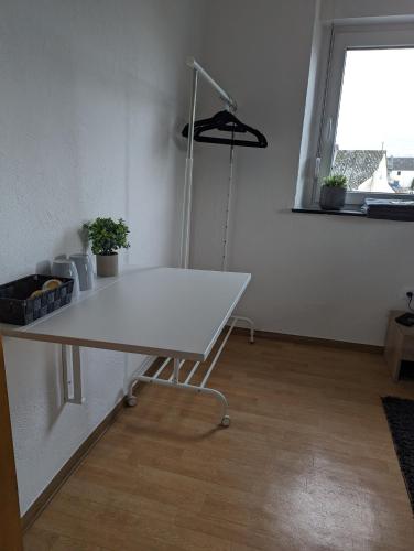 a white table in an empty room with a window at Pension Larifari in Drees