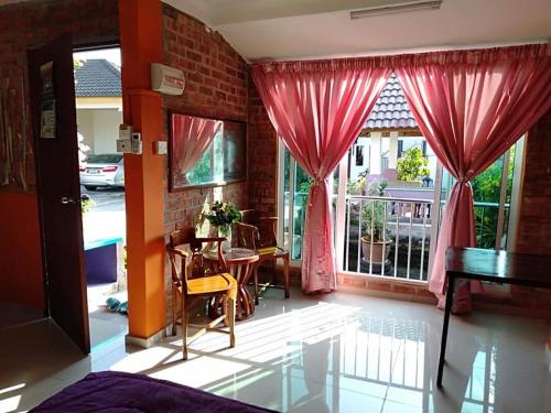 Homestay Syams في Kampong Kubang Bemban: غرفة معيشة مع طاولة ونافذة