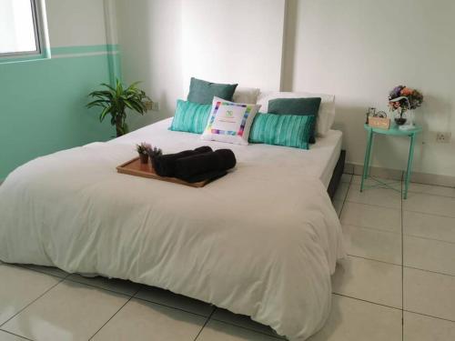 a large white bed with a tray on top of it at Damansara Perdana 3BR for 3-7 Guest Near Ikea in Petaling Jaya