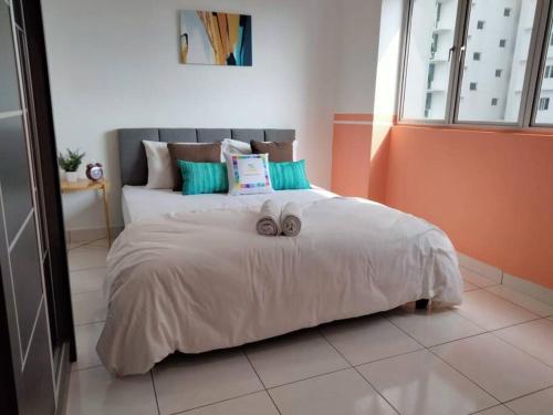 a bedroom with a bed with two slippers on it at Damansara Perdana 3BR for 3-7 Guest Near Ikea in Petaling Jaya