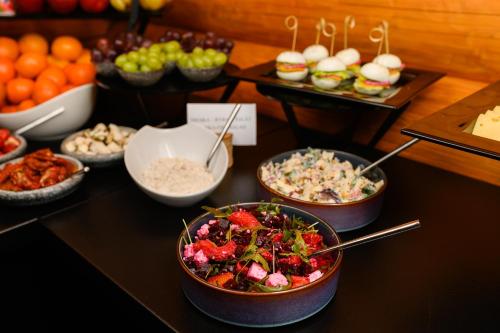 a buffet with bowls of food on a table at Hotel ZEMPLEN in Michalovce