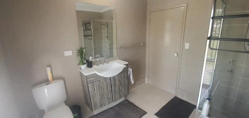 a bathroom with a toilet and a sink and a shower at Honey Wines Australia Meadery Room 1 in Broke