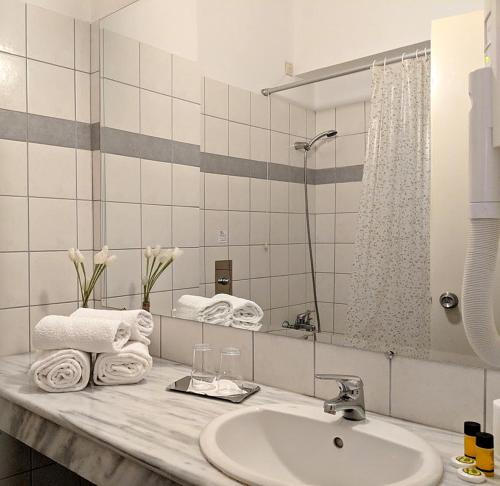 a bathroom with a sink and a mirror and towels at LEPANTO BEACH HOTEL in Nafpaktos