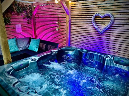 - un bain à remous dans une chambre avec un cœur sur le mur dans l'établissement Clifton Luxury Hot Tub House in Blackpool, à Blackpool