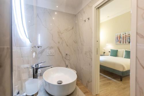 ein Bad mit einem Waschbecken, einer Dusche und einem Bett in der Unterkunft Elegantia Luxury Rooms in Rom