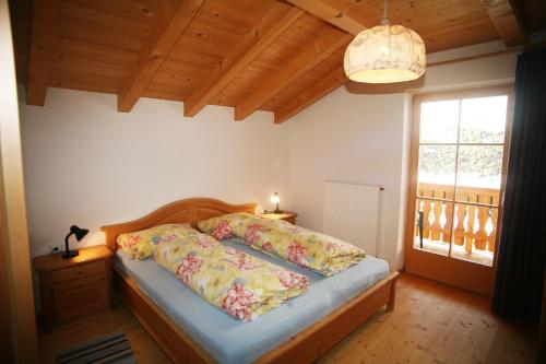 1 dormitorio con cama y ventana en Biohof Unterstein, en Ultimo