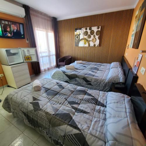 a hotel room with two beds and a tv at Ampuria Inn in Empuriabrava