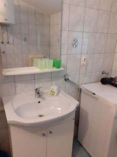 a white bathroom with a sink and a mirror at Ana in Zaglav