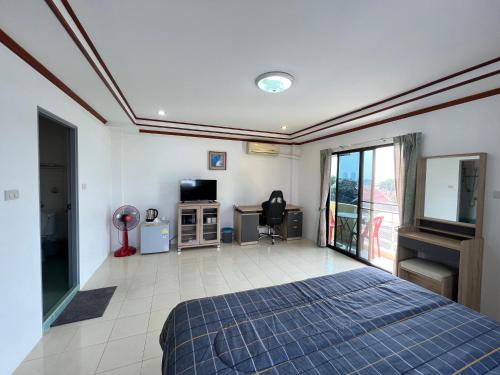 a bedroom with a bed and a tv in a room at Rose Garden Guest House Soi 88 Hua Hin in Hua Hin