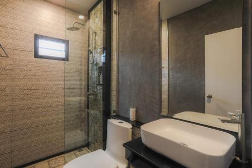 a bathroom with a toilet and a sink and a shower at The Mantra Hotel Kata Noi in Kata Beach