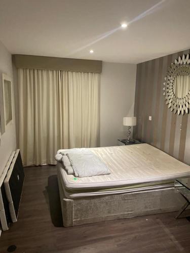een slaapkamer met een groot bed en een spiegel bij Luxurious Furnished Property in Stanmore