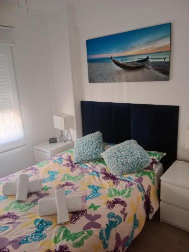 een slaapkamer met een bed en een foto van een boot bij Apartamento Algemsí Cullera in Cullera