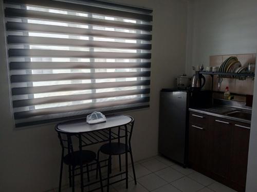 a kitchen with a table and two stools and a window at San Jose Residencias / enchanted kingdom / nuvali / slex / sta. rosa / paseo in Santa Rosa