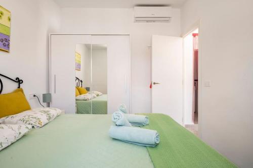 a bedroom with a bed with two blue pillows on it at C´AN PICAFORT NEAR THE SEA in Can Picafort