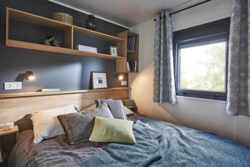 - une chambre avec un lit doté d'oreillers et d'une fenêtre dans l'établissement Camping pays de Beille, aux Cabannes