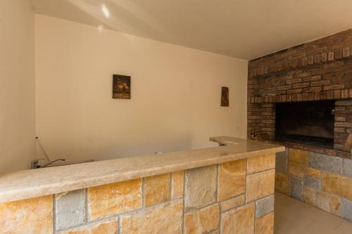 einen Steinkamin im Wohnzimmer mit Ziegelwand in der Unterkunft Apartmani- Lastro in Trogir