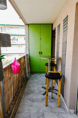 d'une table et de chaises sur un balcon avec un mur vert. dans l'établissement Vue mer et remparts. Entre vieille ville et plages, à Antibes