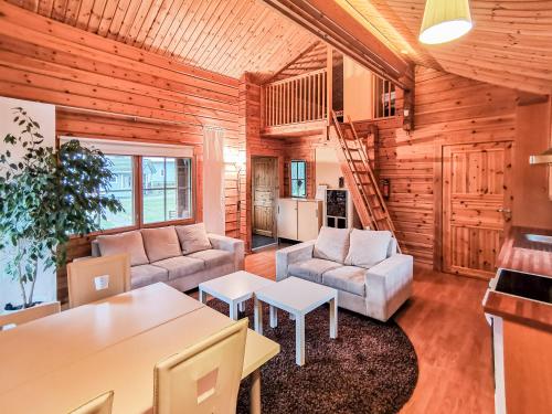 a living room with two couches and a table at Peaceful log cabin in the country in Nurmijärvi