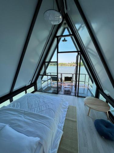 a bed and a table in a room with a window at ทุ่งดินดำ Farm Stay in Ban Kho Wang