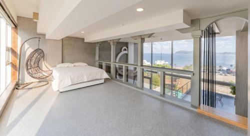 a bedroom with a bed and views of the ocean at Hinokki Haesuzzim Resort in Geoje 