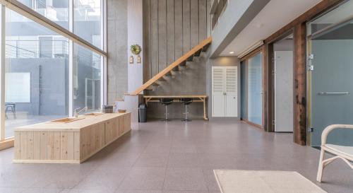 a lobby with a staircase and a table and chairs at Hinokki Haesuzzim Resort in Geoje 