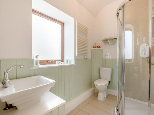 a bathroom with a sink and a toilet and a shower at Appletree Cottage in Kirkton of Tealing