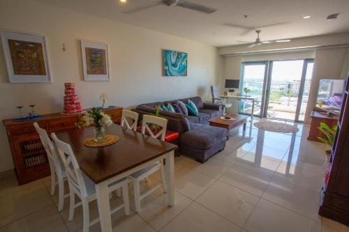 een woonkamer met een tafel en een bank bij Darwin luxury apartment in Darwin