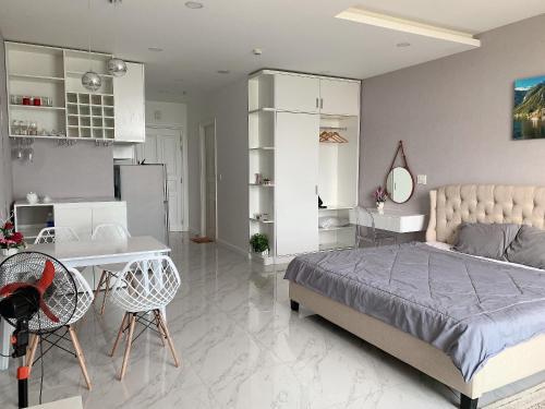 a bedroom with a bed and a desk and a kitchen at Căn hộ 1br Ocean Vista - SeaHome in Phan Thiet