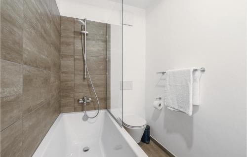 biała łazienka z wanną i toaletą w obiekcie 2 Bedroom Lovely Apartment In Lembruch-dmmer See w mieście Lembruch