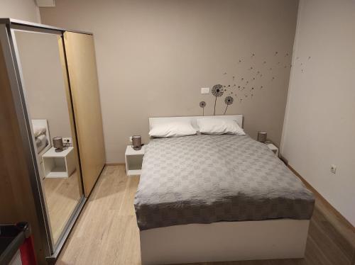 a small bedroom with a bed and a mirror at Apartma Jelendol in Tržič