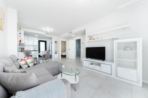 uma sala de estar com um sofá e uma televisão em Apartamento Milan em Campoamor