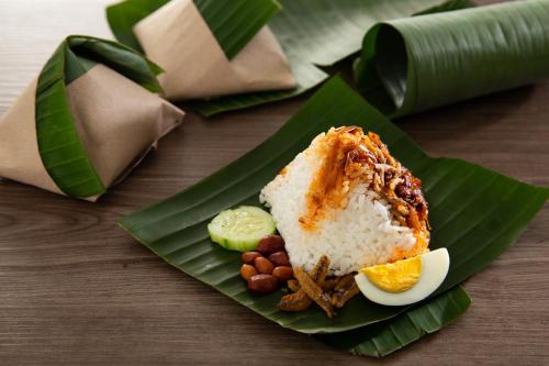 a plate of food with rice and beans on a banana leaf at OHHSEM Hotel in Semporna