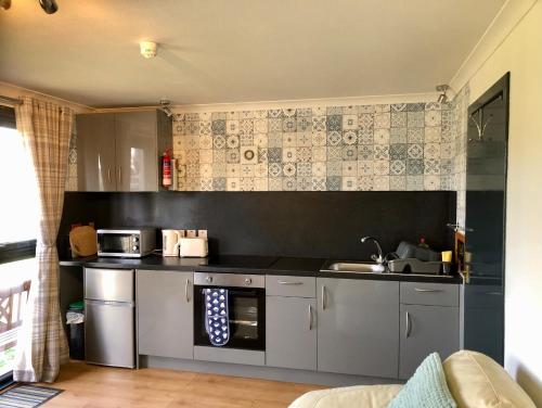 a kitchen with a sink and a stove top oven at Kilcoy Chalets in Muir of Ord